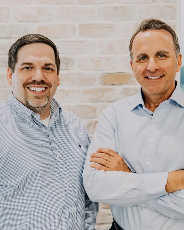 Dr. Michael Maher and Dr. David Montz standing together in front of a brick wall.