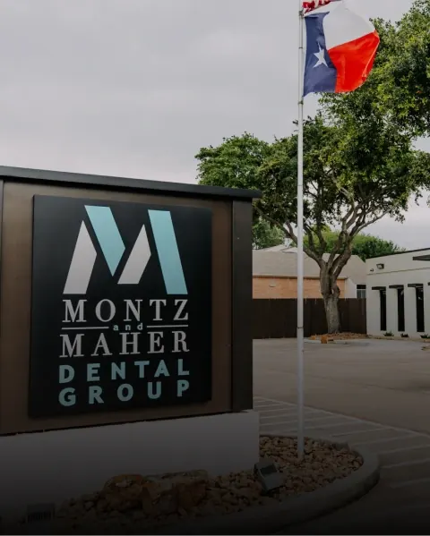 The Montz and Maher Dental Group sign outside the Pearland office, with the Texas flag behind it.