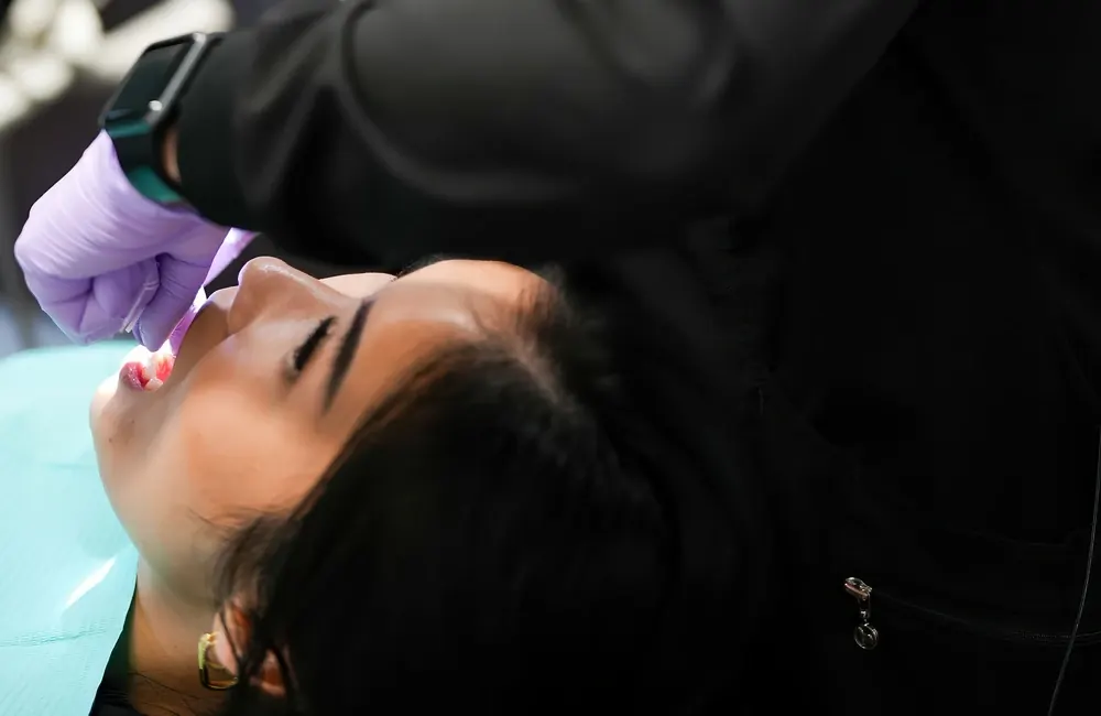 A patient reclined in the treatment chair while a clinician works.