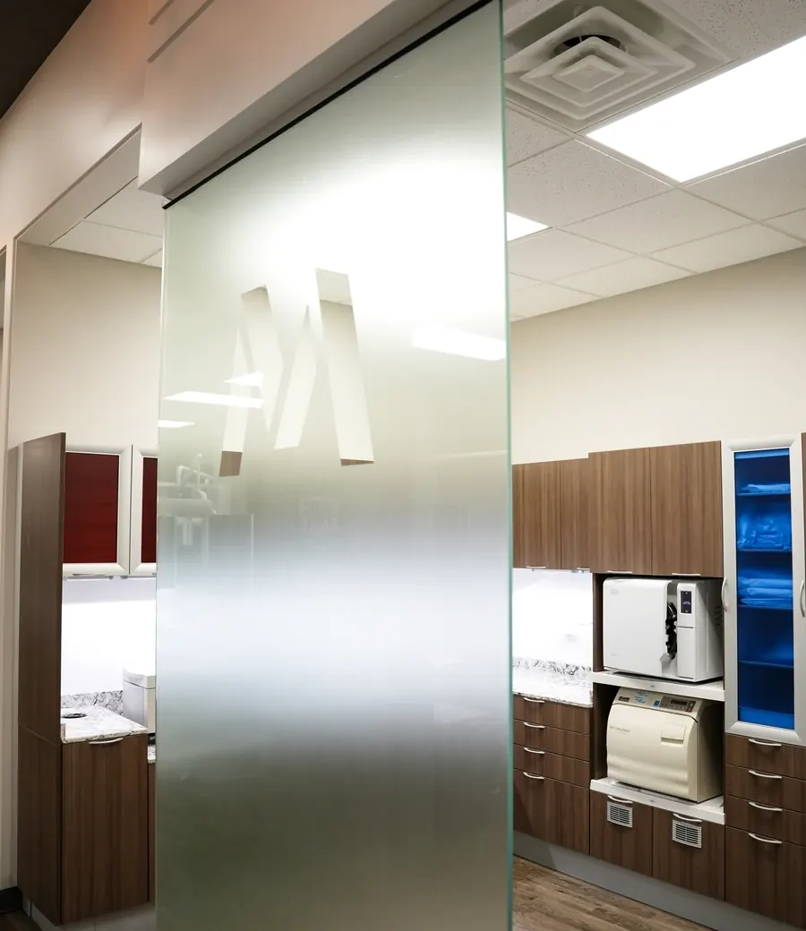 The in-house lab area behind a frosted glass partition, with cabinetry along the wall.